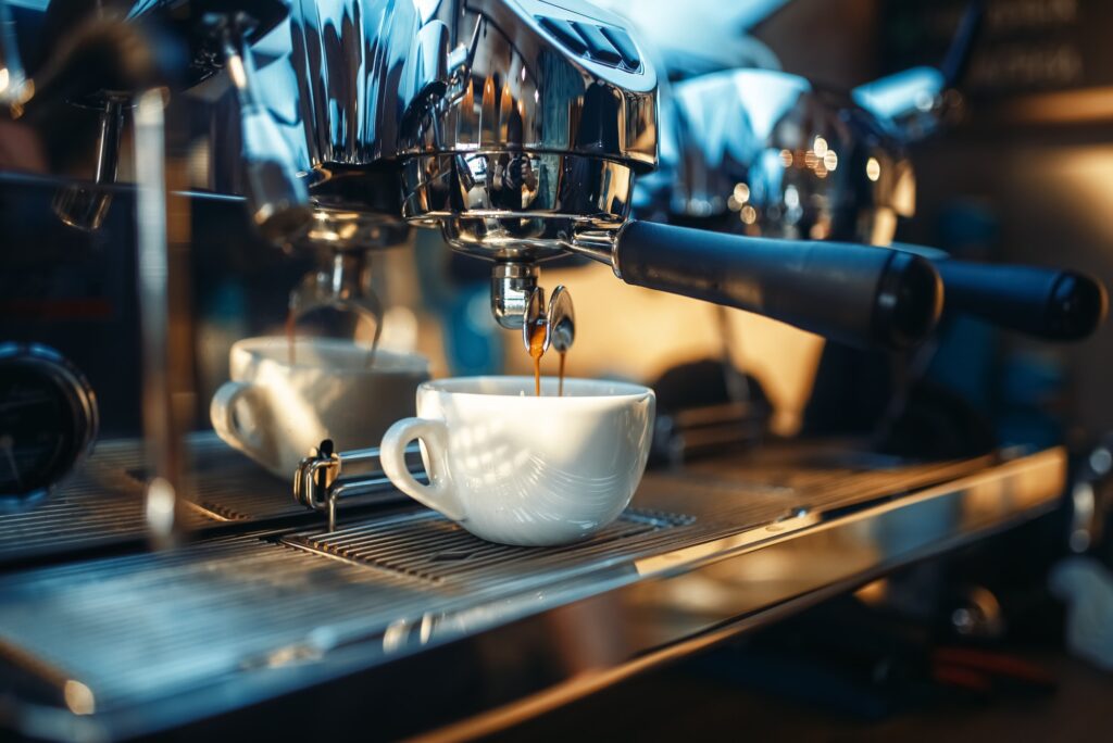 Espresso machine pours fresh black coffee closeup